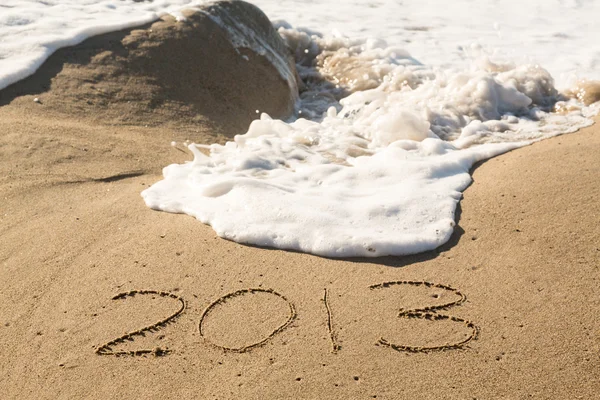 2013 in sand being covered by sea waves — Stock Photo, Image