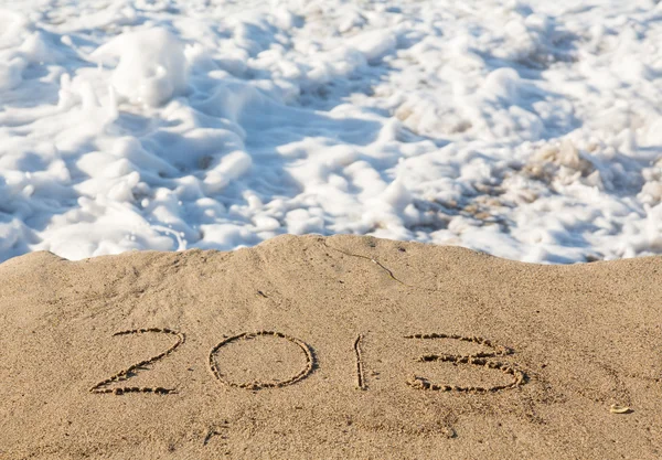 2013 in sand being covered by sea waves — Stock Photo, Image