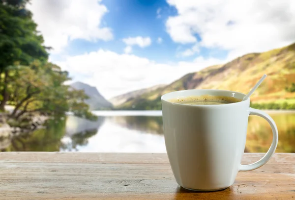 Kopp kaffe på träbord av sjön — Stockfoto