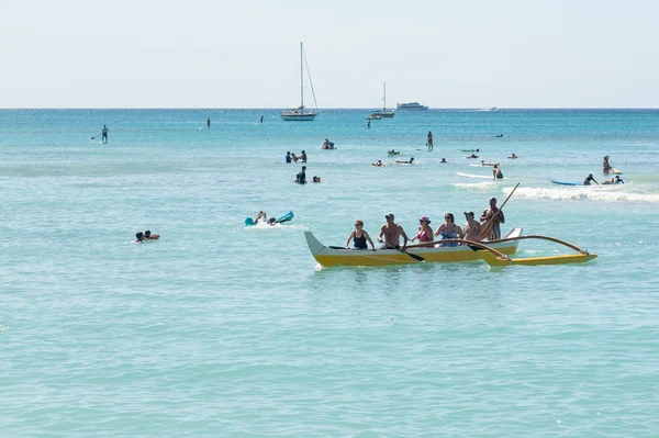 Turistas frente a la costa de Waikiki en canoa tradicional — Foto de Stock