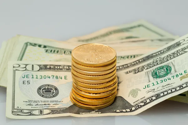 Stack of twenty dollar bills with gold coins — Stock Photo, Image