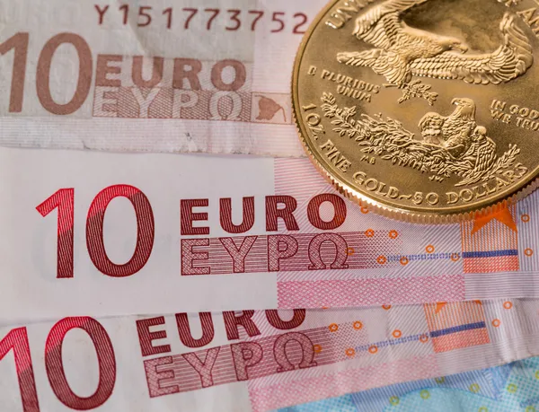 Gold coins on ten and twenty euro notes bills — Stock Photo, Image