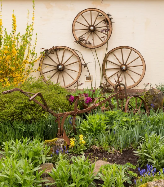 Bauerngarten mit Wagenrädern dekoriert — Stockfoto