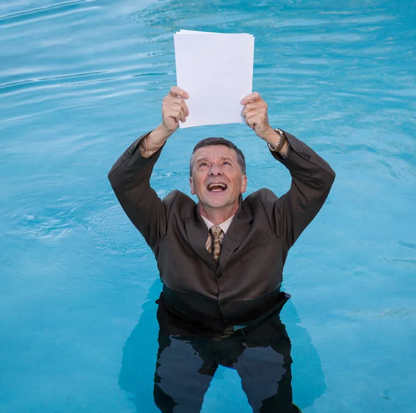 Senior man met lege papierwerk in water — Stockfoto