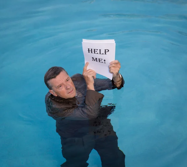 Senior man holding help me paperwork in water — Stockfoto