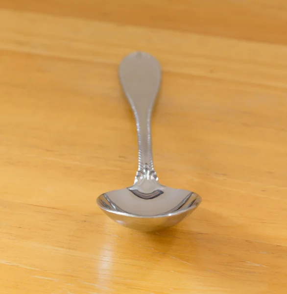 Serving spoon stainless steel on wood — Stock Photo, Image