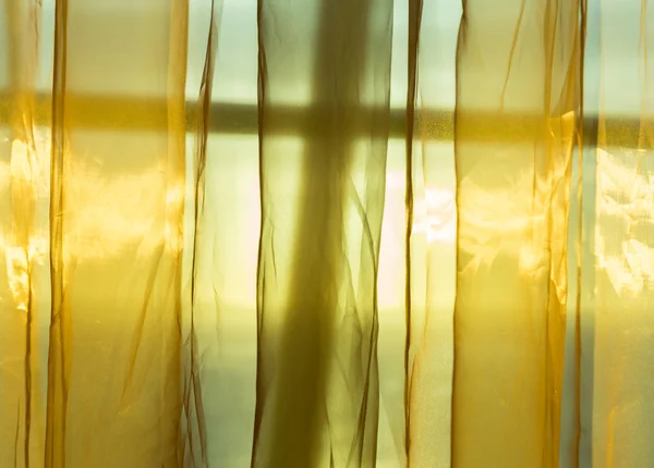 Gyllene netto gardiner sköld solsken bakom fönstret — Stockfoto