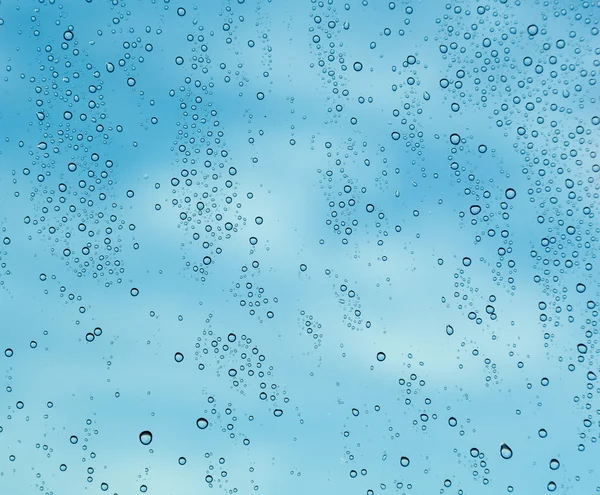 Regendruppels op venster van een schip op zee met wolken — Stockfoto