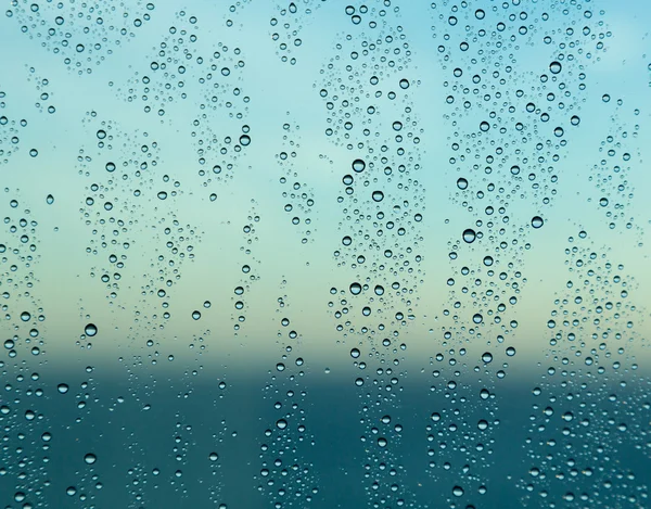 Gocce di pioggia sul finestrino di una nave in mare con orizzonte — Foto Stock