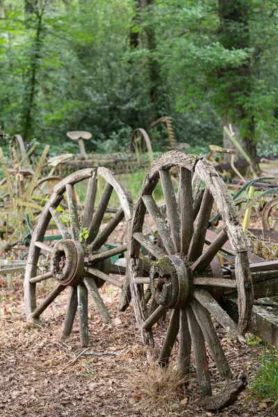 Two old wooden cartwheel against wood cart — Stock Photo, Image