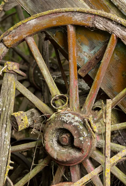 Old wooden cartwheel against wood cart — Stock Photo, Image