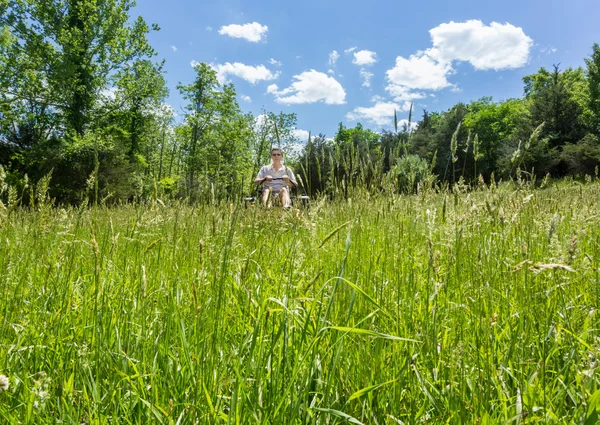 Senior man on zero turn lawnmower in meadow — Stock Photo, Image