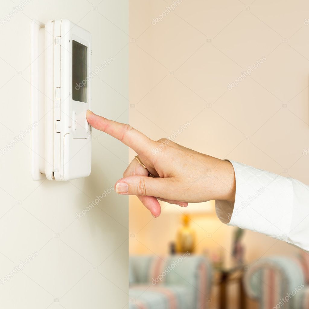 Caucasian lady pressing modern thermostat