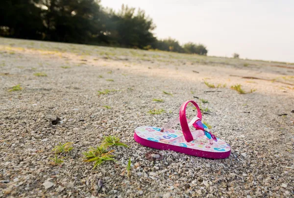 Enda barn flipflop på tom beach — Stockfoto