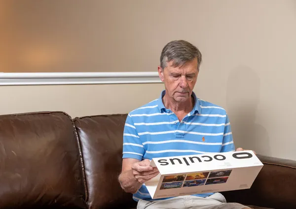 Senior man looking at new Oculus Quest 2 128GB VR headset box — Stock Photo, Image