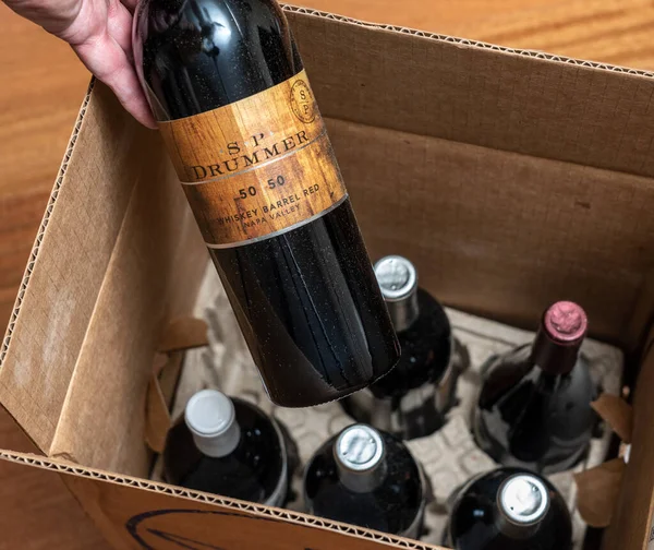 Hombre mayor examinando un caso de seis vinos de Bodega Desnuda después de la entrega a domicilio — Foto de Stock