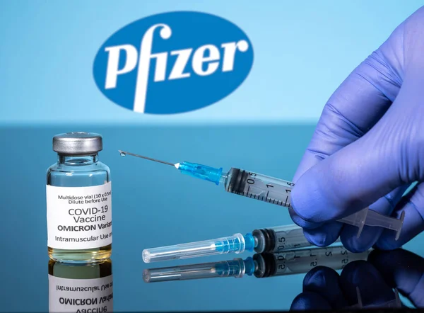 Covid-19 vakcína pro variantu Omicron v injekční lahvičce s injekční stříkačkou proti pozadí Pfizer — Stock fotografie