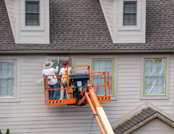 Two Home Painters Articulating Boom Lift Spray Painting Townhouse — Stockfoto