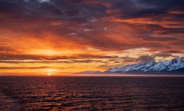 Güneş ufukta dağlarda ve Fairweather Dağı 'nda Alaska' daki Buzul Körfezi Ulusal Parkı 'nda.