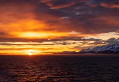 Güneş ufukta dağlarda ve Fairweather Dağı 'nda Alaska' daki Buzul Körfezi Ulusal Parkı 'nda.