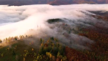 İnsansız hava aracı, tepenin üzerinden geçen sisin üzerinden uçuyor. 4k, İHA videosu ile çekilmiştir..