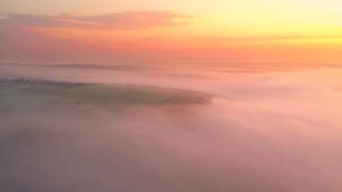 İnsansız hava aracı güneş doğarken taze bulutlardan oluşan fantastik bir okyanusun üzerinde uçuyor. 4k, İHA videosu ile çekilmiştir..