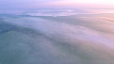 İnsansız hava aracı, tarım arazilerini kaplayan yoğun bir sabah sisinin üzerinde uçuyordu. Sinematik hava çekimi. Konum Dinyester Nehri, Ukrayna, Avrupa. Toprağın güzelliğini keşfedin. 4k, İHA videosu ile çekilmiştir..