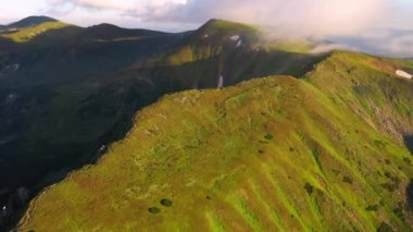 İnsansız hava aracı bir yaz günü güneşin aydınlattığı yeşil tepelerin üzerinde uçar. 4k, İHA videosu ile çekilmiştir..