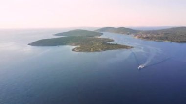 Güneşli bir günde gök mavisi bir körfezden ateş etmek. Yeri Kvarner Körfezi, Cres, Hırvatistan, Avrupa. Egzotik takımadaların görüntüleri. Sinematik hava çekimi. Dünyanın güzelliği. 4k, İHA videosu ile çekilmiştir..