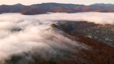 İnsansız hava aracı, dağ sıralarını kaplayan yoğun sabah sisinin üzerinde uçuyor. 4k, İHA videosu ile çekilmiştir..