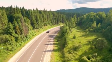 İnsansız hava aracı dağ yolunda bir bisikletçiyi takip ediyor. 4k, İHA videosu ile çekilmiştir..
