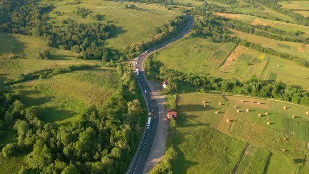 ドローンは緑の高山草原を通過する道路上を飛ぶ 4Kで撮影されたドローンビデオ — ストック動画