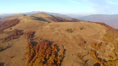 Güneşli bir günde sakin renkli dağların üzerinden bir dron uçar. 4k, İHA videosu.
