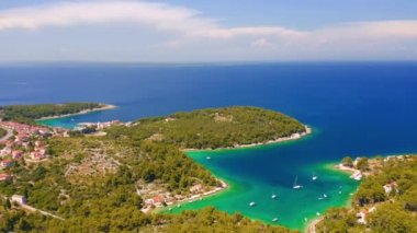 Helikopter Adriyatik kıyısındaki eski Mali Losinj kasabasının üzerinde uçuyor. 4k, İHA videosu ile çekilmiştir..