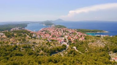 Helikopter Adriyatik kıyısındaki eski Mali Losinj kasabasının üzerinde uçuyor. 4k, İHA videosu ile çekilmiştir..