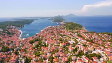 Helikopter Adriyatik kıyısındaki eski Mali Losinj kasabasının üzerinde uçuyor. 4k, İHA videosu ile çekilmiştir..