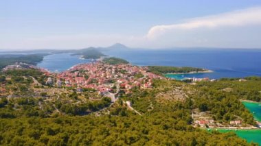 Helikopter Adriyatik kıyısındaki eski Mali Losinj kasabasının üzerinde uçuyor. 4k, İHA videosu ile çekilmiştir..
