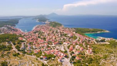 Helikopter Adriyatik kıyısındaki eski Mali Losinj kasabasının üzerinde uçuyor. 4k, İHA videosu ile çekilmiştir..