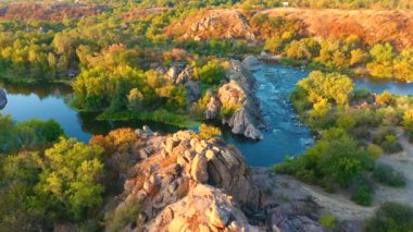 Drone, ağaçlarla çevrili hızlı bir Güney Böceği nehrinin üzerinden uçuyor. 4k, İHA videosu ile çekilmiştir..