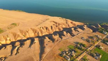 İnsansız hava aracı kil dağlarda nehrin kenarından uçuyor. 4k 'lık bir videoda çekildi.