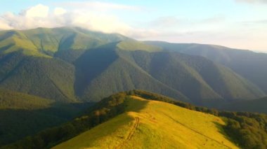 Güneş ışığında yeşil dağ sıraları, kuş bakışı. 4k, İHA videosu ile çekilmiştir..