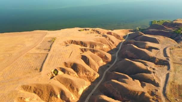 ドローンは粘土の山の中の川の浸透した平均上を飛ぶ 4Kビデオで撮影 — ストック動画