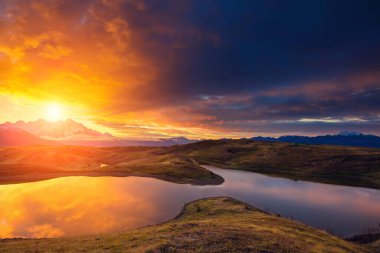 Koruldi Gölü 'nün altında bulutlu bir gökyüzü var. Ushba. Dramatik sabah sahnesi. Yukarı Svaneti, Mestia, Gürcistan, Avrupa. Yüksek Kafkasya sırtı. Sıcak tonlama etkisi. Güzellik dünyası.