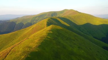 Yeşil dağ sıralarının üzerinde uçan bir dronun muhteşem manzarası. 4k, İHA videosu ile çekilmiştir..