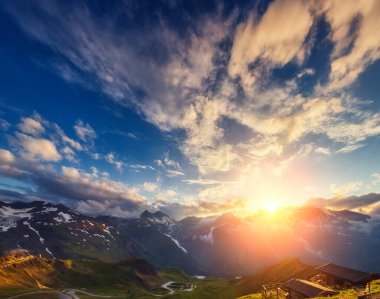 Alacakaranlıkta gün ışığıyla parlayan tepelerin muhteşem manzarası. Dramatik ve resimli bir sabah sahnesi. Ünlü Grossglockner High Alpine Yolu, Avusturya. Avrupa. Sanatsal resim. Güzellik dünyası.