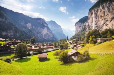 Güneş ışığıyla parlayan harika bir dağ köyü manzarası. Resimli ve muhteşem bir sahne. Popüler turist eğlencesi. İsviçre Alpleri, Lauterbrunnen Vadisi Staubbach Şelalesi, Avrupa. Güzellik dünyası