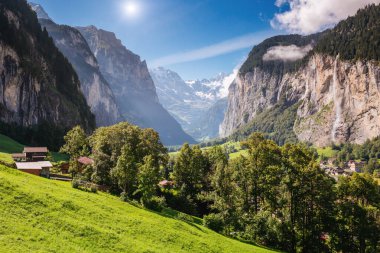 Güneş ışığıyla parlayan harika bir dağ köyü manzarası. Resimli ve muhteşem bir sahne. Popüler turist eğlencesi. İsviçre Alpleri, Lauterbrunnen Vadisi Staubbach Şelalesi, Avrupa. Güzellik dünyası