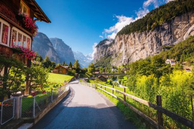 Güneş ışığıyla parlayan harika bir dağ köyü manzarası. Resimli ve muhteşem bir sahne. Popüler turist eğlencesi. İsviçre Alpleri, Lauterbrunnen Vadisi Staubbach Şelalesi, Avrupa. Güzellik dünyası