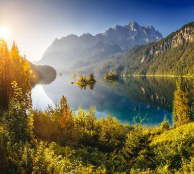 Eibsee Gölü 'ndeki Eibsee Dağı eteğindeki adaların manzarası ve turkuaz su. Zugspitze. Sabah sahnesi. Bavyera Alp, Avrupa 'nın ünlü tatil beldesi Garmisch-Partenkirchen. Sanatsal resim. Güzellik dünyası.