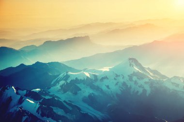 Uçağın yüksekliğiyle dağ sırasının muhteşem manzarası. Resim gibi ve muhteşem bir sabah sahnesi. Çapraz işlenmiş retro ve vintage tarzı. Instagram tonlama etkisi. Güzellik dünyası.